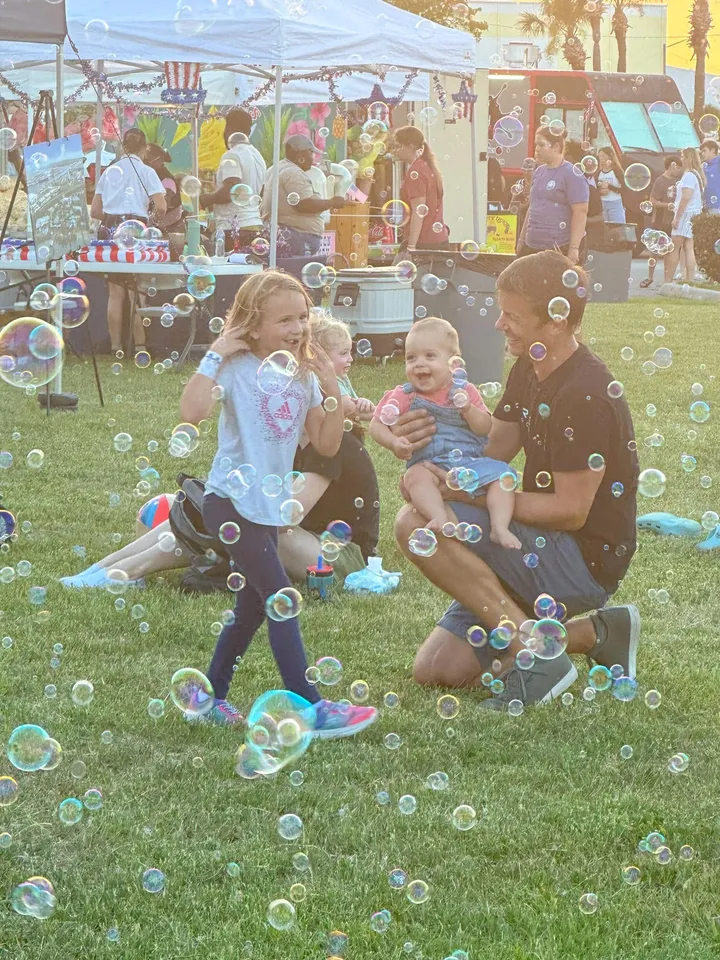 An evening outdoor community event with bubbles